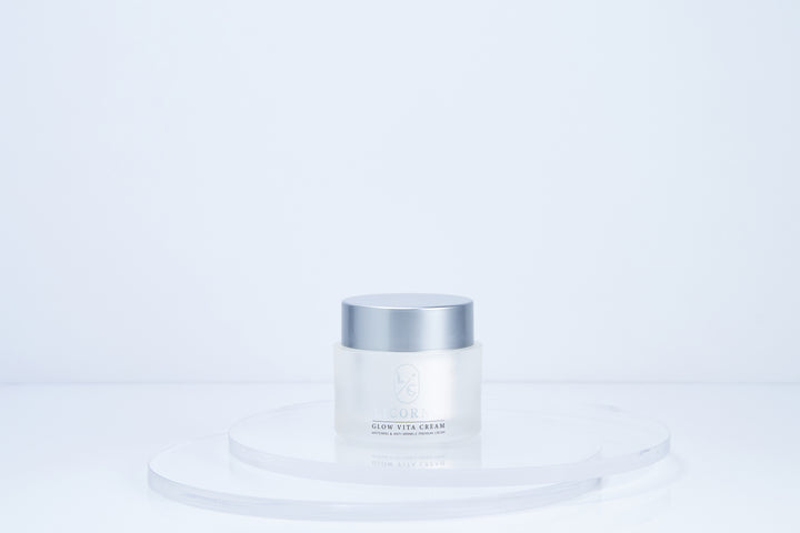 White skincare jar with silver lid on a light blue background