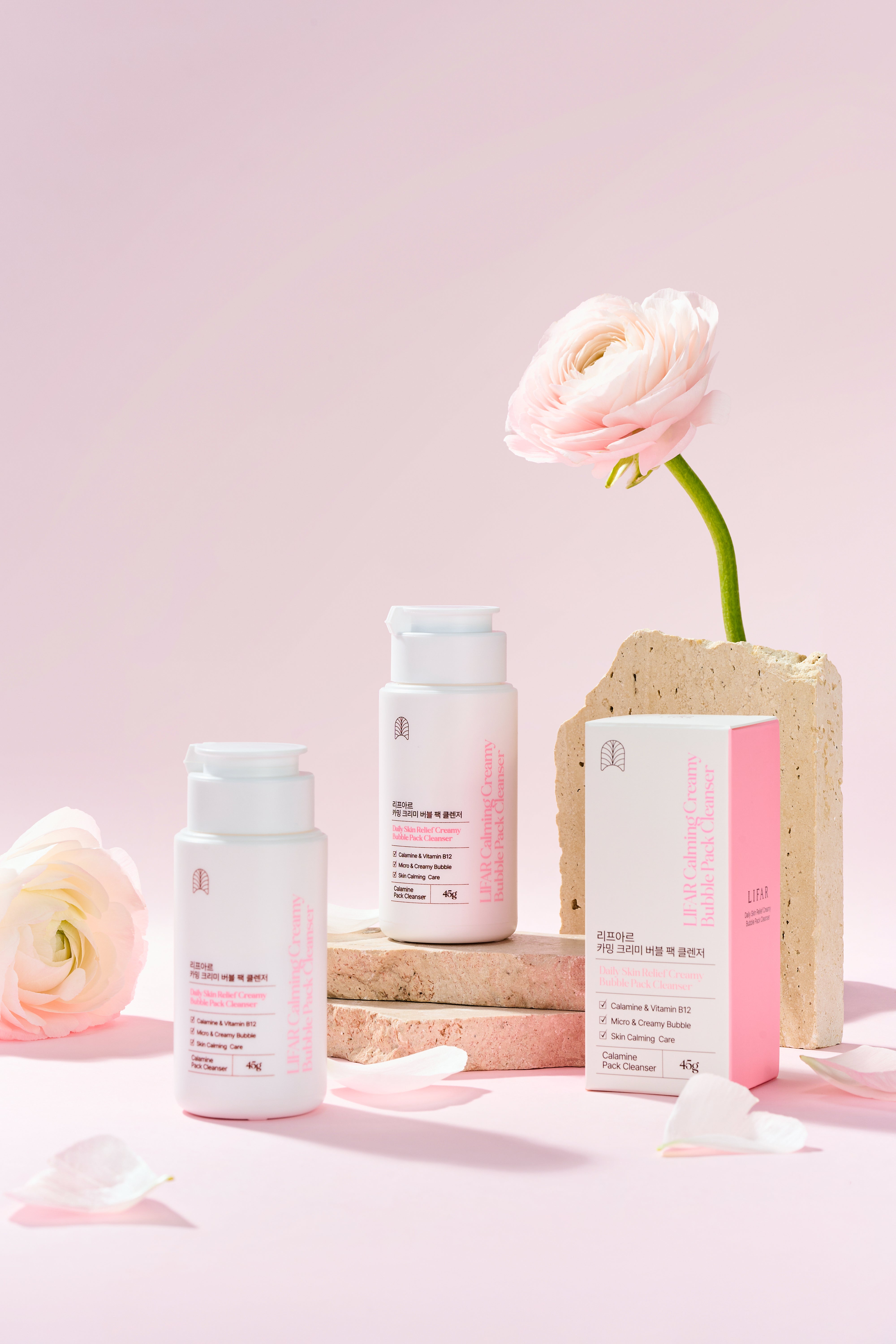 Skincare products with a flower on a pink background