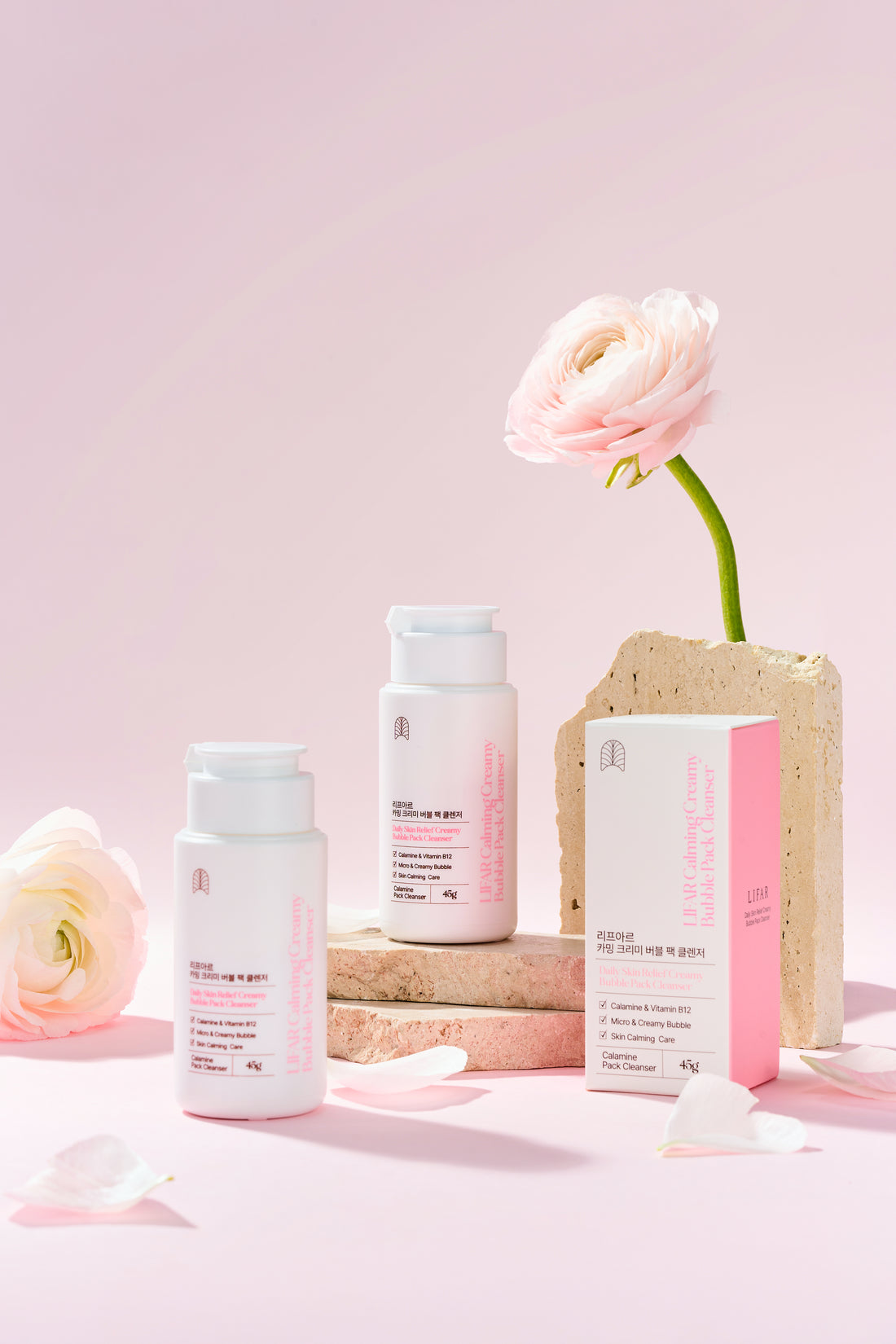 Skincare products with a flower on a pink background