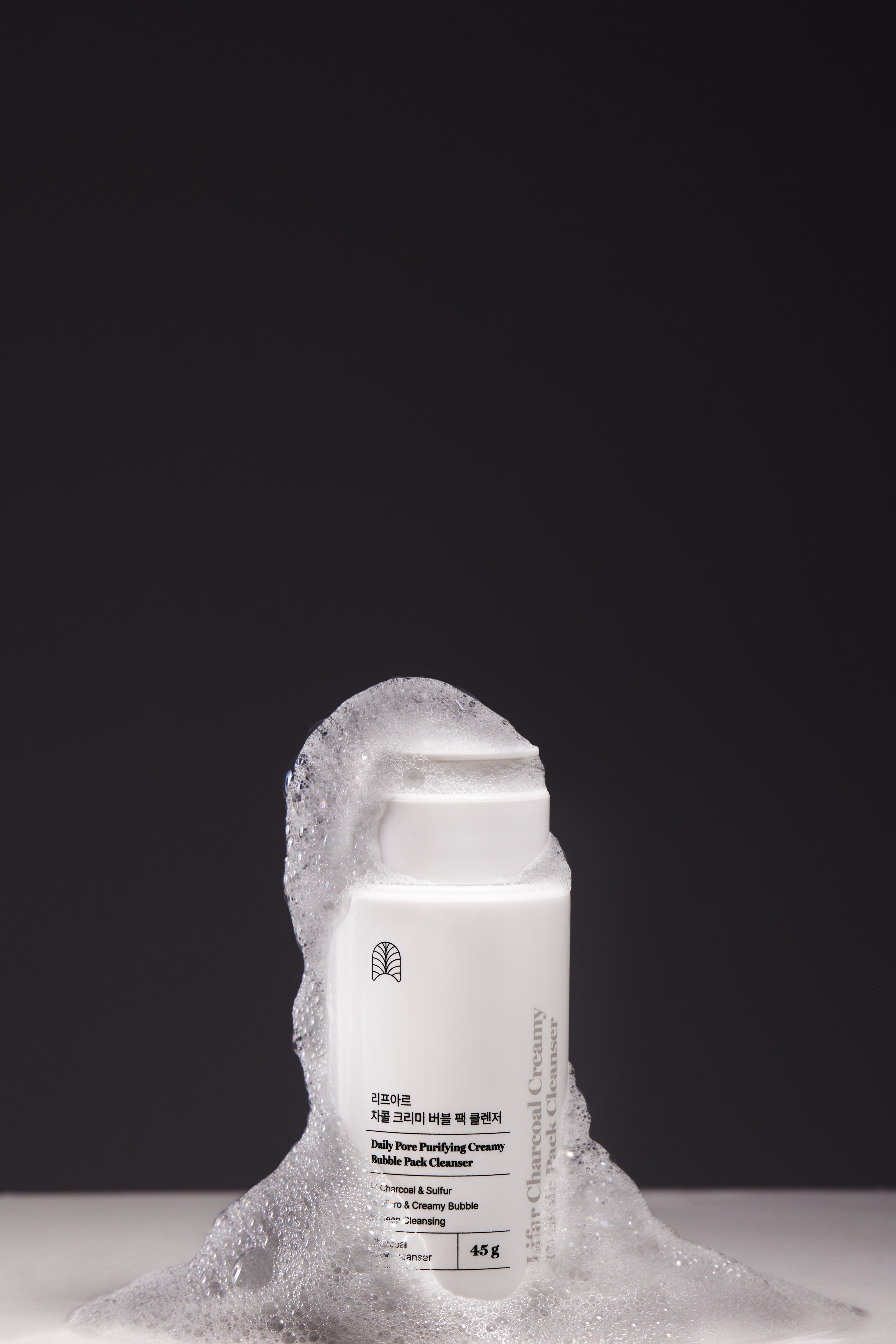 Skincare product with foam on a dark background