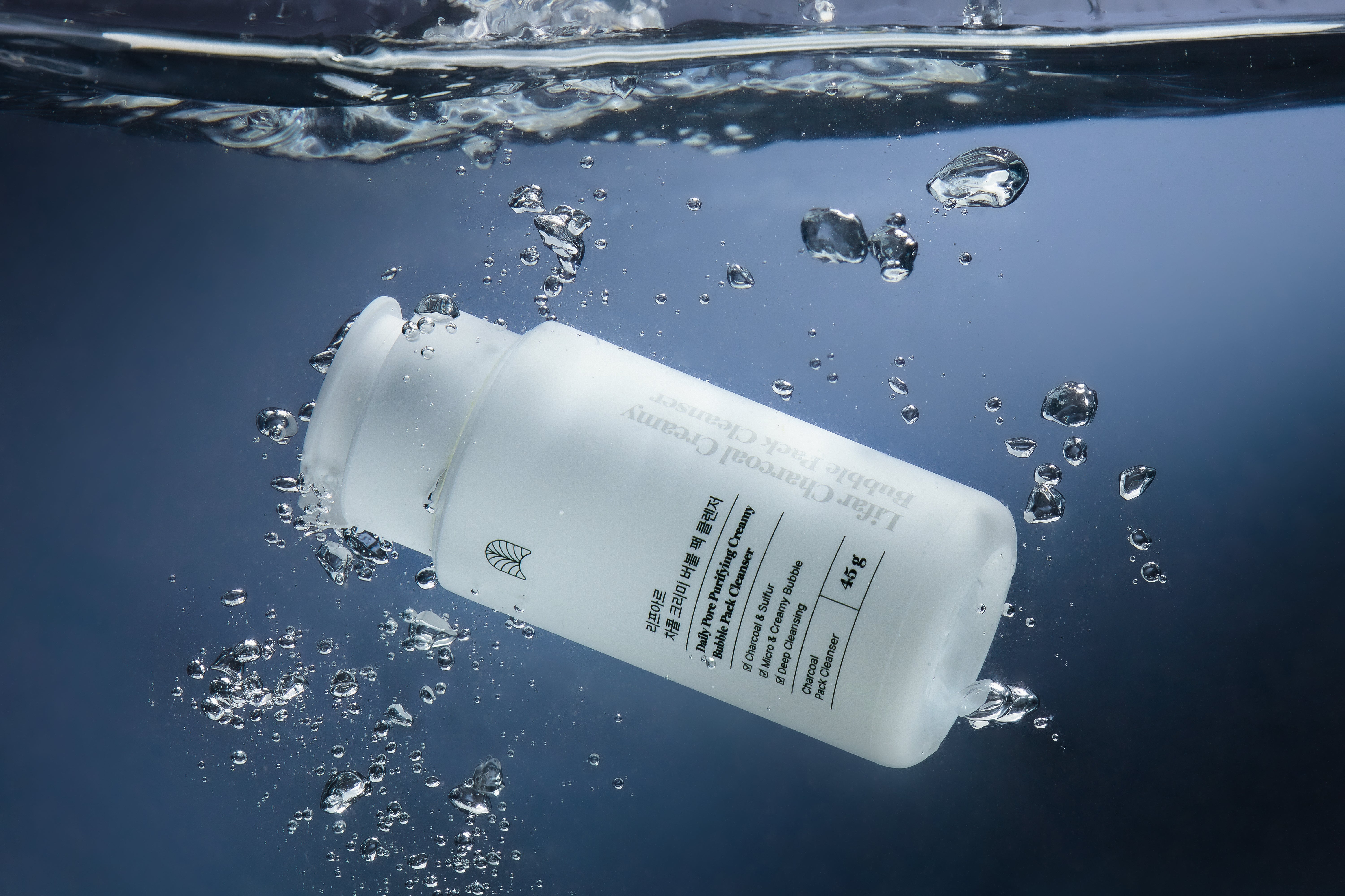 White bottle with text partially submerged in water