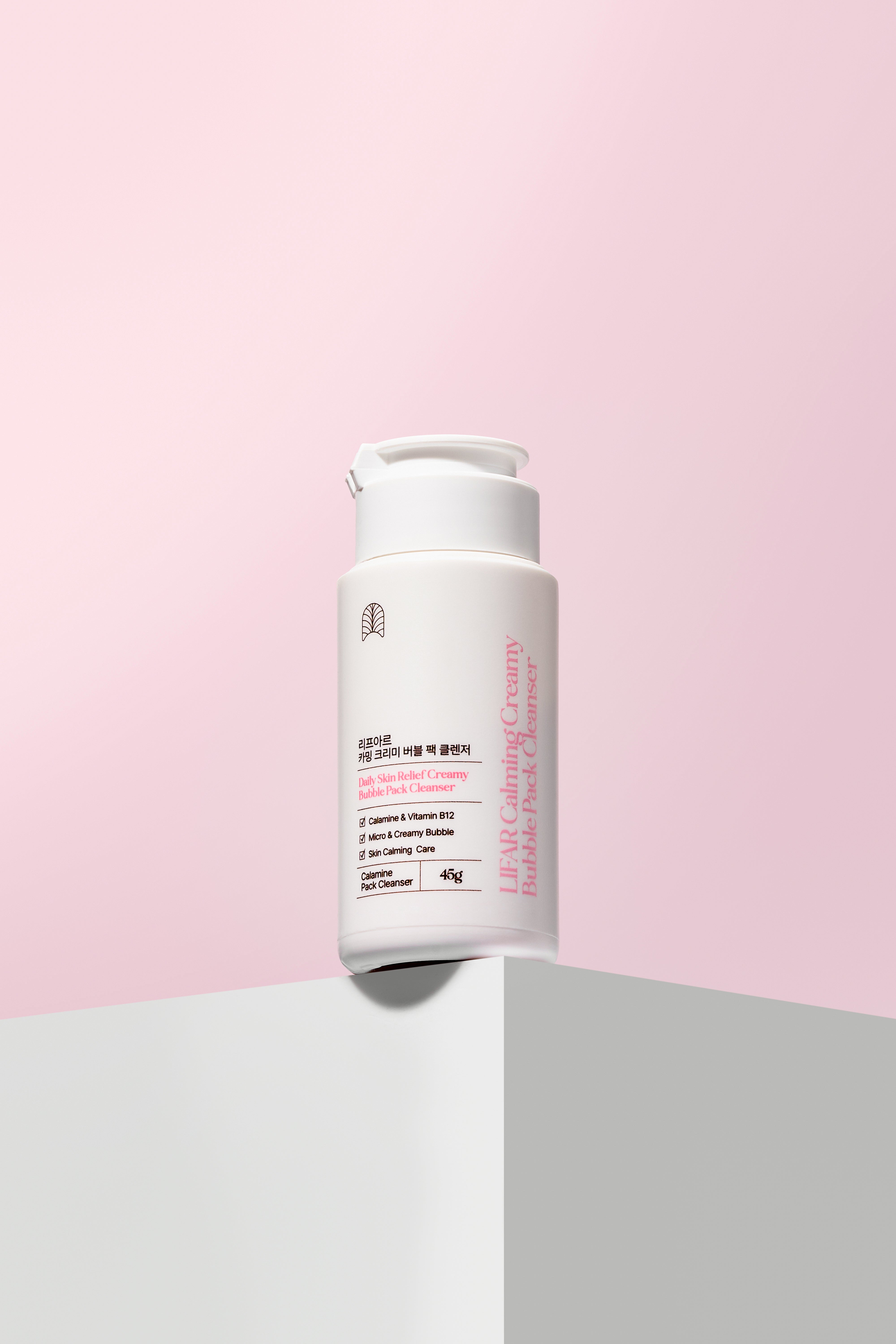 Skincare bottle on a pink and gray background